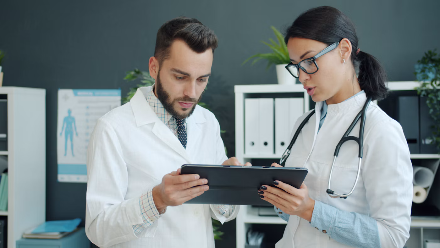 Zwei Ärzte besprechen Inhalte auf einem Tablet